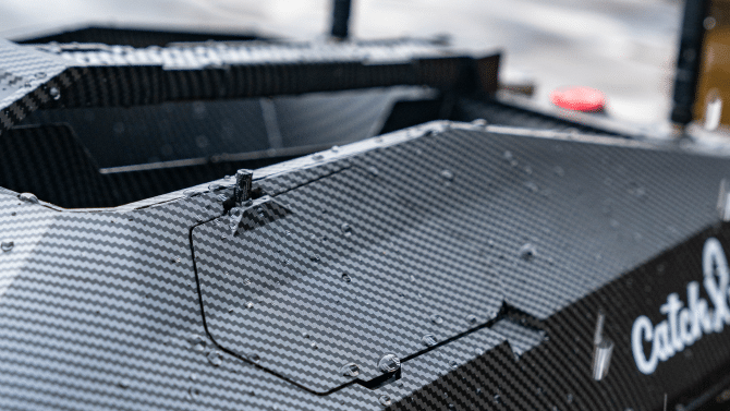 Close-up of a carbon fiber bait boat with a sleek futuristic design, featuring durable construction and advanced technology