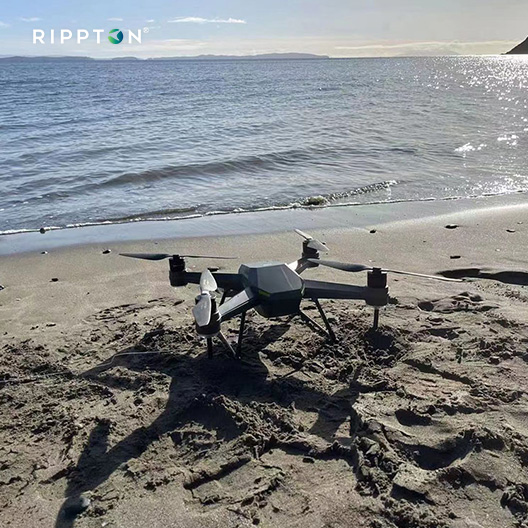 SharkX waterproof drone for fishing on sandy beach near ocean, designed for bait release and professional fishing missions