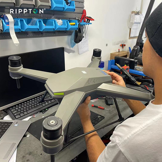 Technician inspecting SharkX fishing drone with modular design and waterproof features for bait release